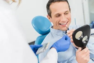 man choosing the color of dental veneers he wants to get for his procedure at Gina Biedermann DDS