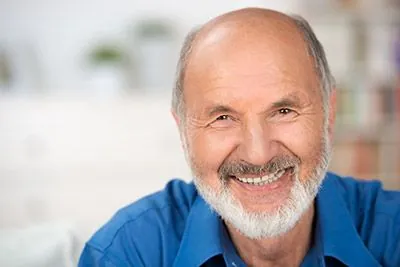 man happy with his smile after getting dental implants at Gina Biedermann DDS