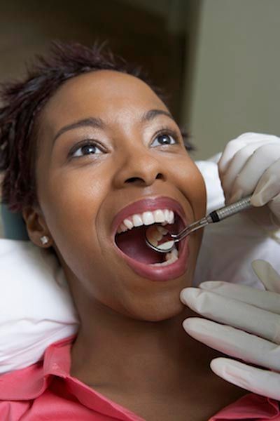 woman receiving a dental checkup at Gina Biedermann DDS