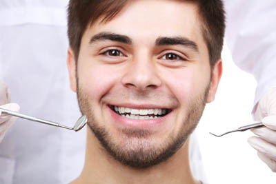 man smiling during his dental checkup at Gina Biedermann DDS