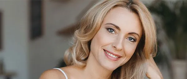 Woman smiling with natural, radiant skin and blonde hair