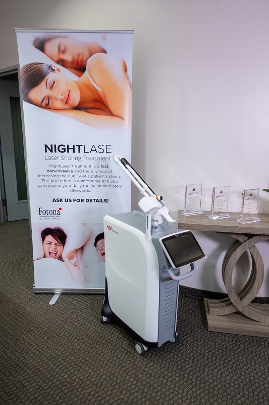 NightLase laser device next to promotional banner in clinic